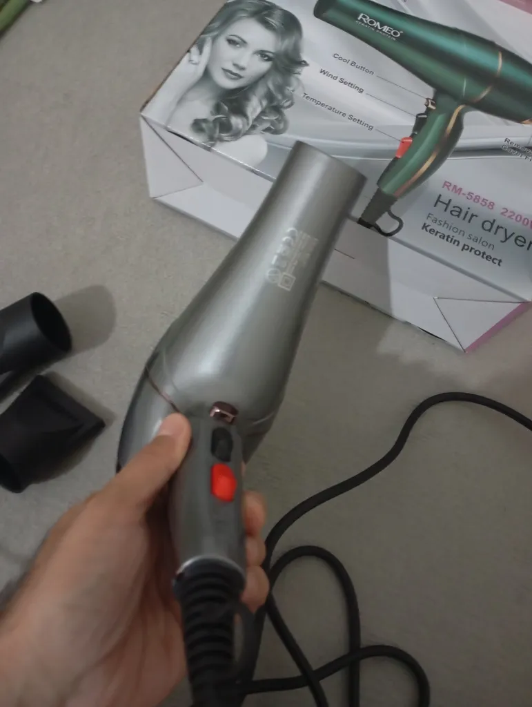 سشوار حرفه‌ای رومئو مدل RM-5858، موتور AC با توان مصرفی 2200 وات، دارای قابلیت باد سرد، طراحی ارگونومیک، دارای حلقه آویختن، با حالت صاف‌کننده و حجم‌دهنده، وزن 450 گرم، تنظیم حرارت 3 حالته و کنترل سرعت 2 حالته، به همراه متمرکزکننده باریک